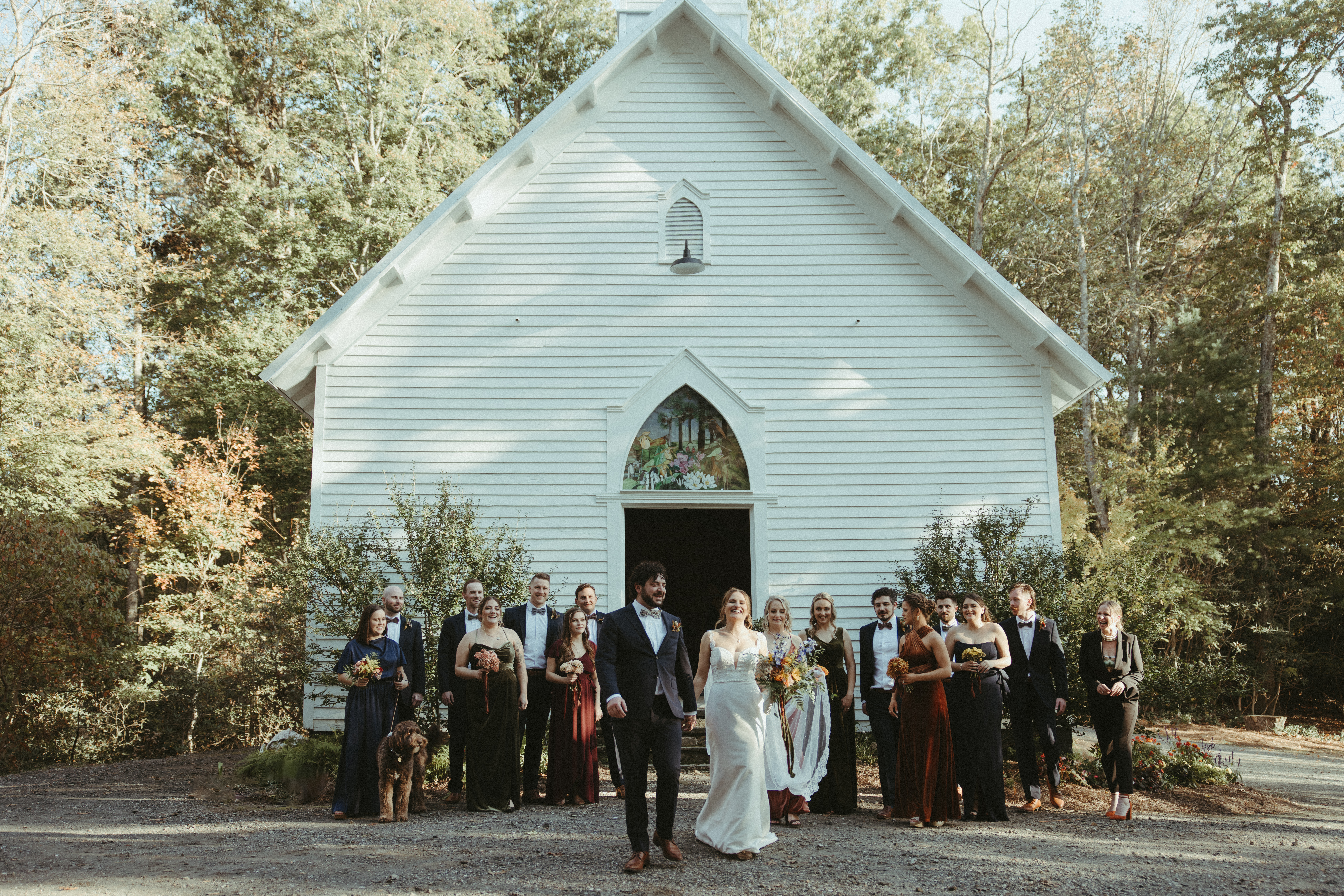 wedding party photos in front of white chapel 